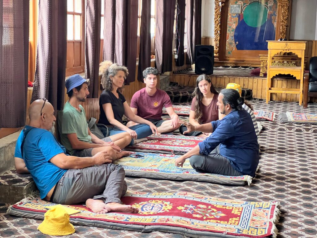 Global travellers attending an introduction to Pranic Healing inside a monastery in Leh, Ladakh, learning about prana, chakras and the human energy system.